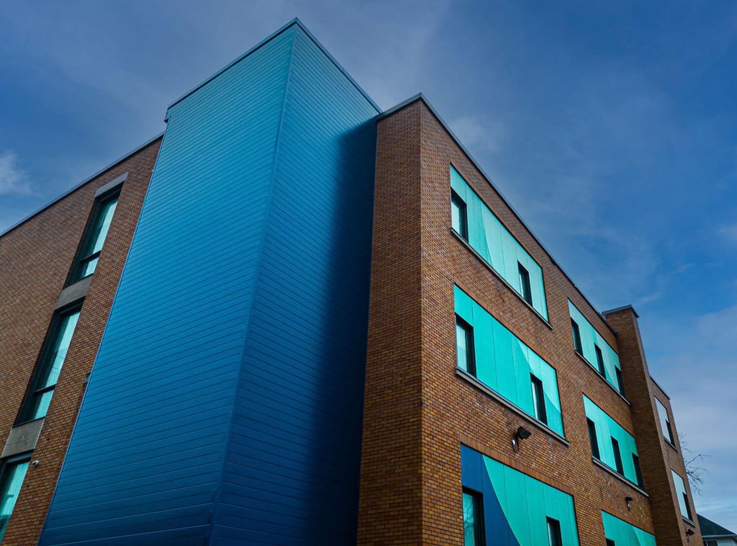 29 Brick building with turquoise and blue cladding around windows