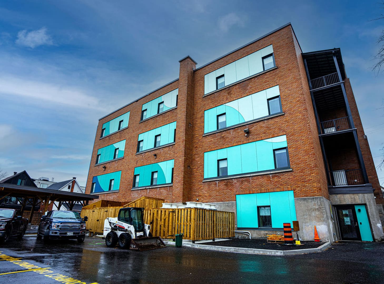 32 Brick commercial building with turquoise ACM panels and vehicles