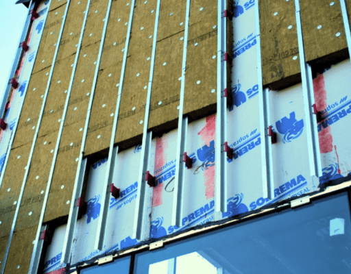 exterior Building envelope installation showing insulation boards and vertical metal framing
